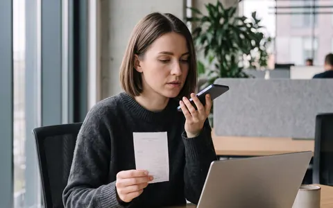 Finance professional dictating receipt details into a smartphone